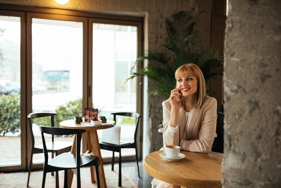 Young attractive businesswoman talking on the mobile phone in a coffee shop